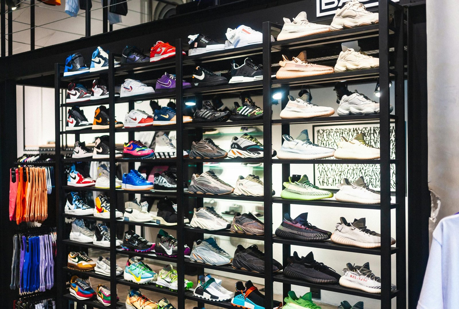 A shelf full of colorful sneakers from various brands on display in a modern retail store.